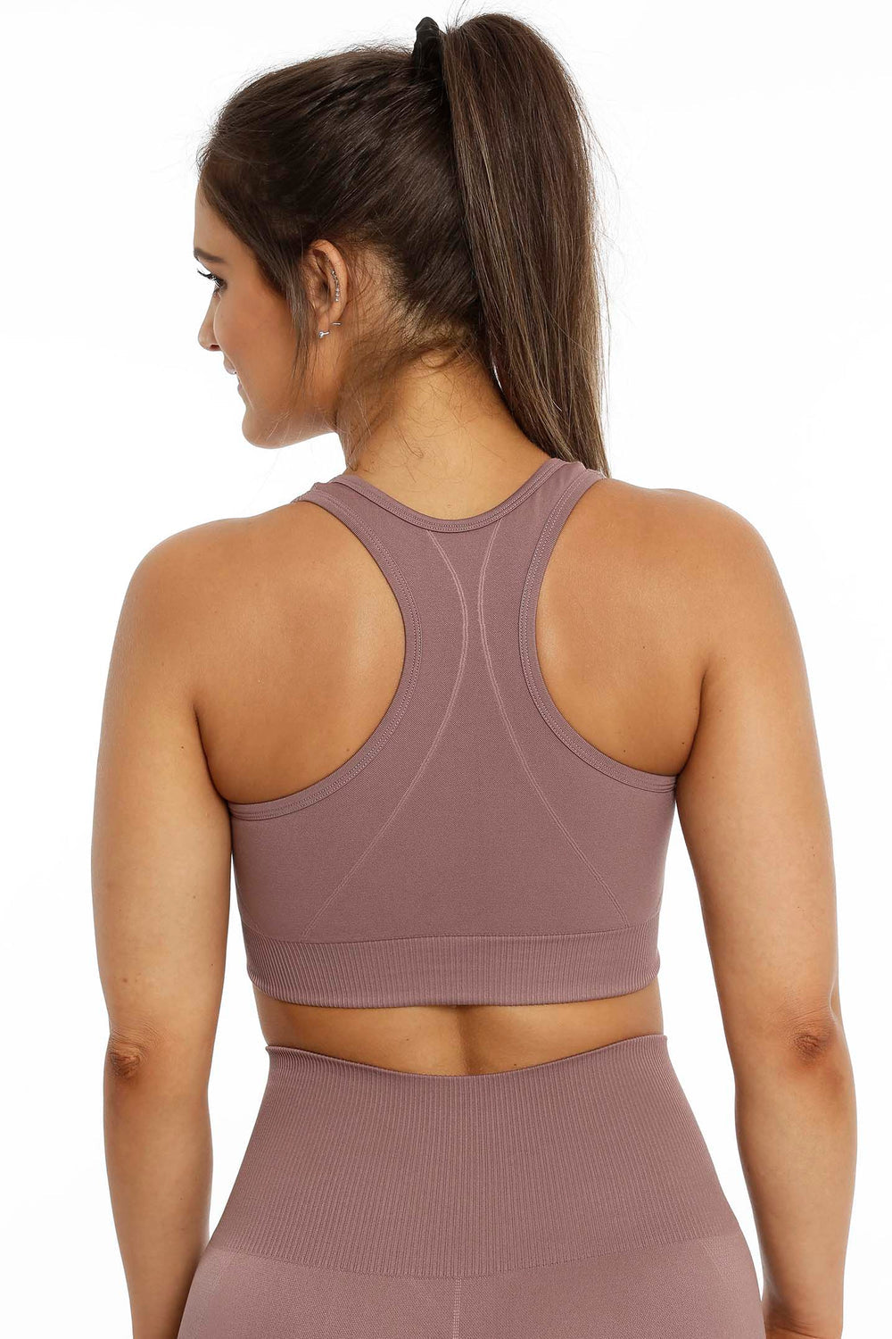 Racerback-ryg og ribkant forneden på den rosabrune top, med matchende tights nedenunder.
