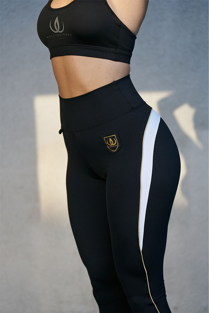 De sorte tights har guldmærke ved hoften og hvid stribe med guldkant langs siden.