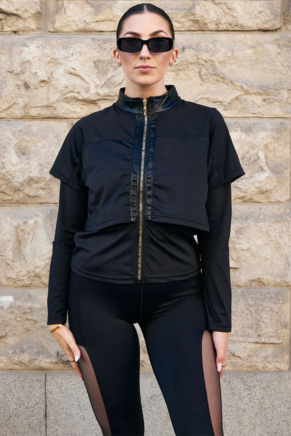 Edge Træningsjakke Gold Zip med guldfarvet lynlås lige midtfor, til sorte tights med mesh.