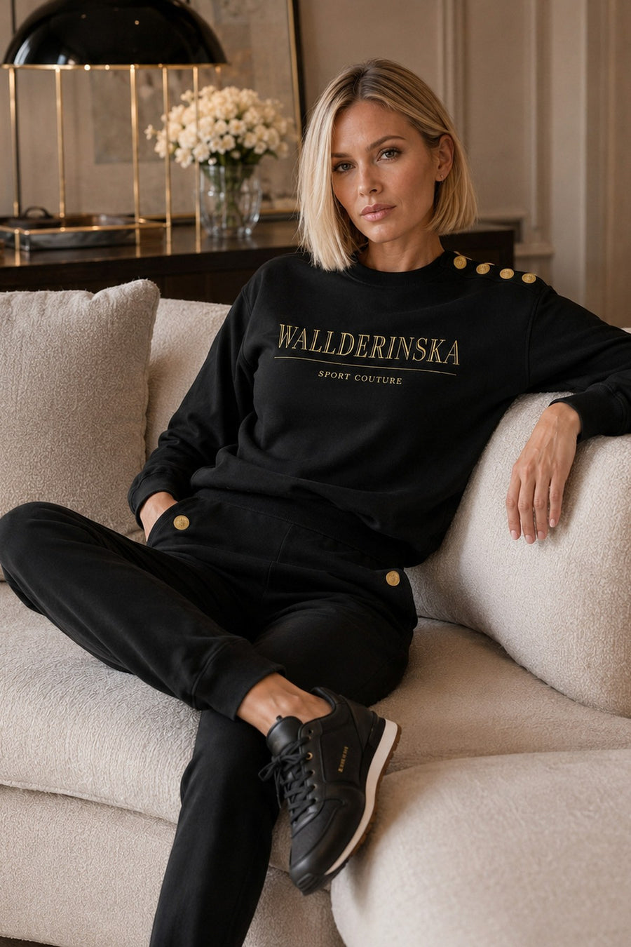 Edge Gold Button Sweater og Edge Gold Button Bukser i en lys sofa.