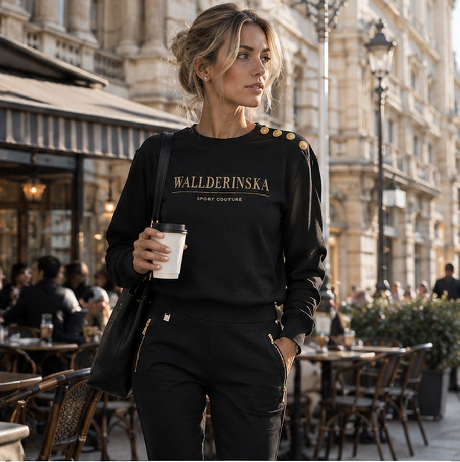 Edge Gold Button Sweater og Edge Casual Zip Bukser med kaffe uden for en café i byen.